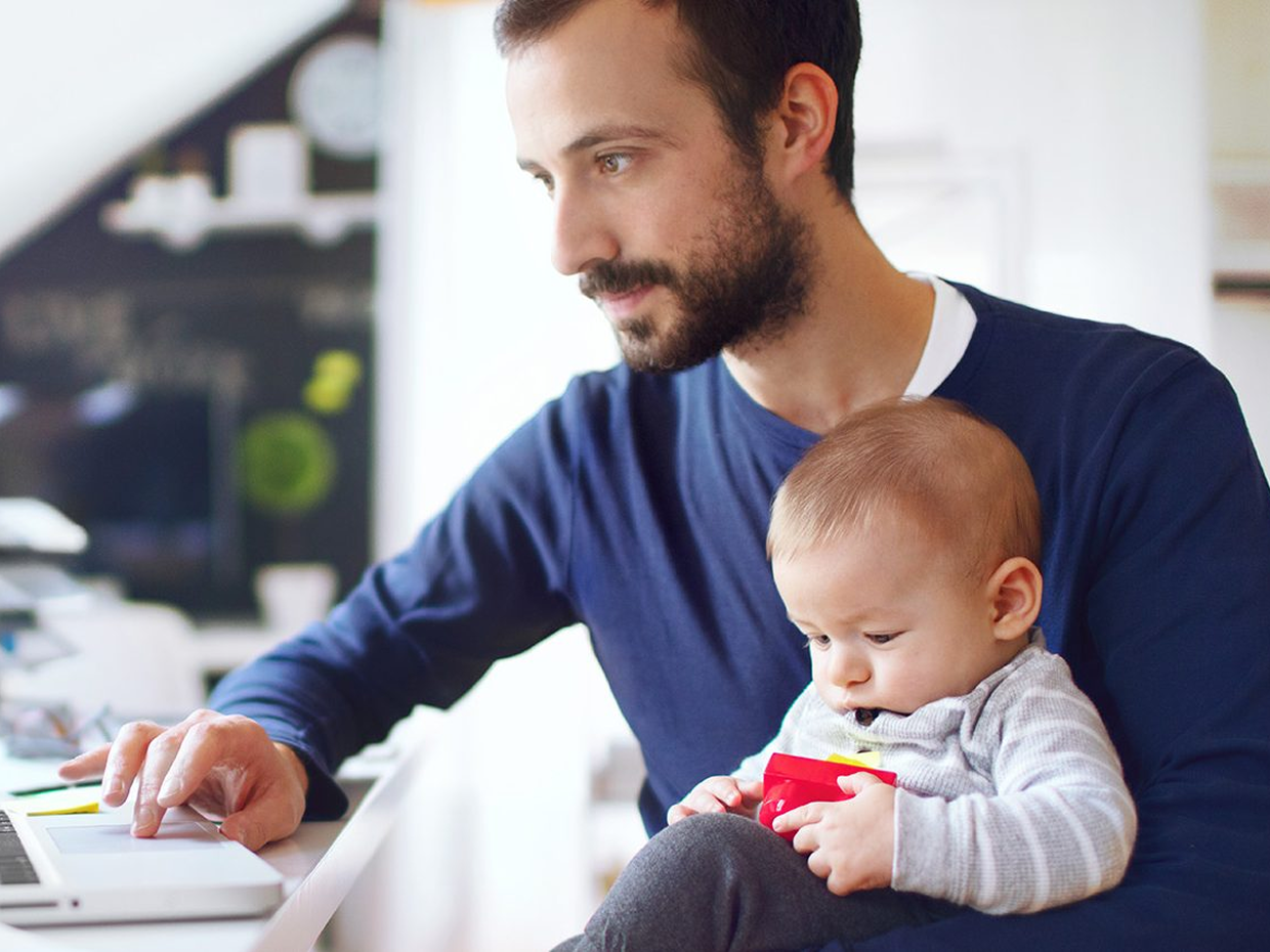 Man working while holding a child