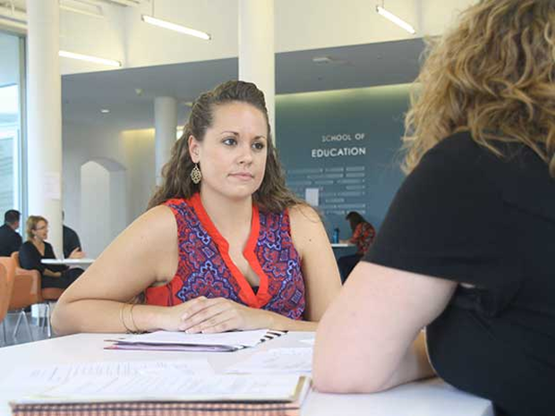 Two people in a seated discussion.
