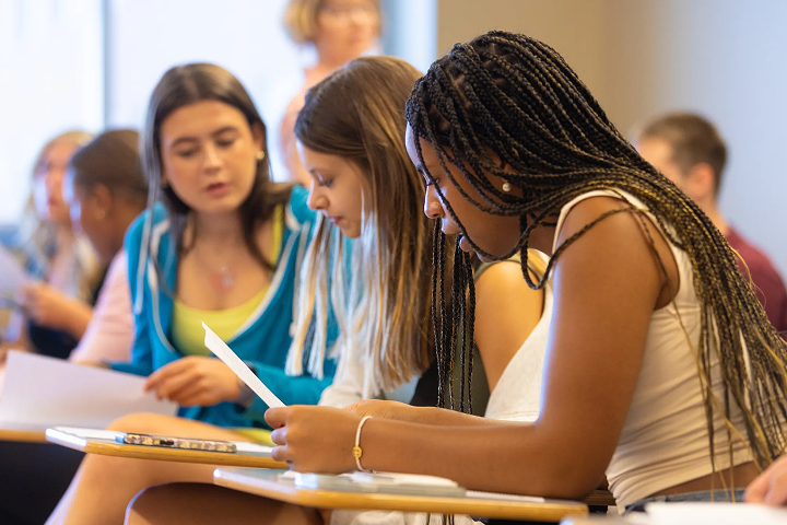 Students reviewing papers in a classroom.
